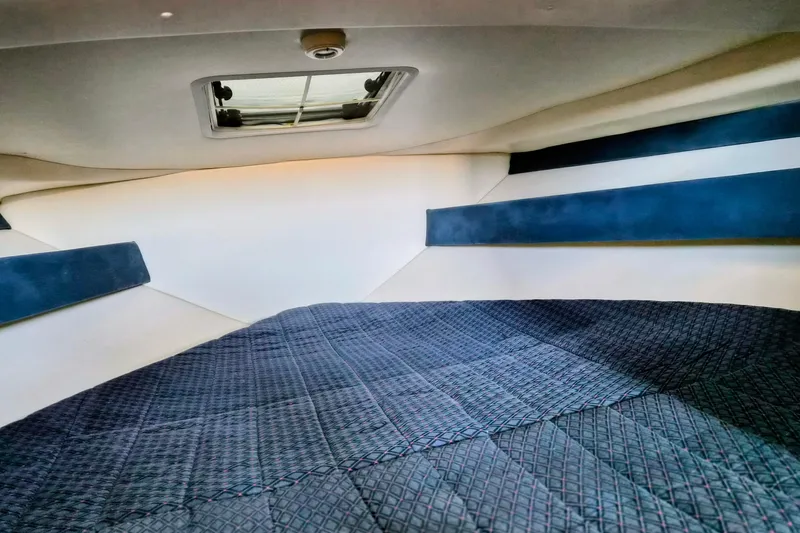 Slide: The Image of 2007 Bayliner Discovery 288 cabin interior with bed and overhead hatch. - 16