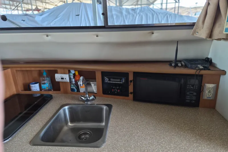 Slide: The Image of 2007 Bayliner Discovery 288 interior with sink, microwave, and countertop appliances. - 17