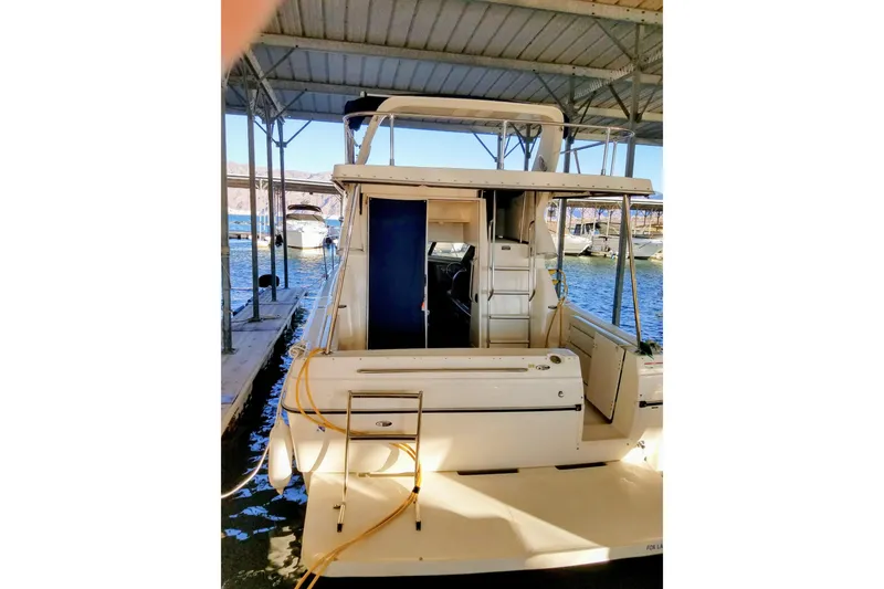 Slide: The Image of 2007 Bayliner Discovery 288 docked in a covered marina, rear view. - 4