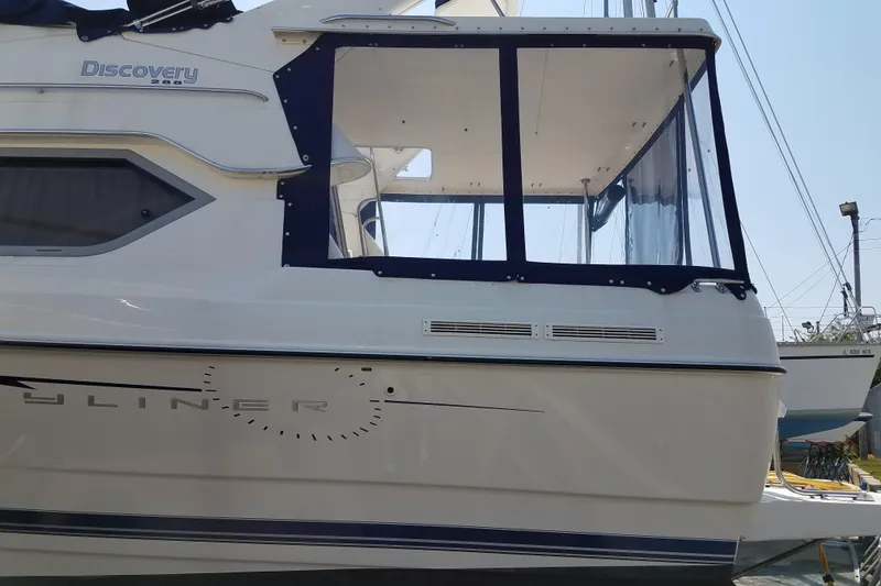 Slide: The Image of 2007 Bayliner Discovery 288 boat with enclosed cabin, docked at a marina. - 6