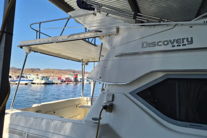 Slide: The Image of 2007 Bayliner Discovery 288 boat docked at marina with scenic background. - 7