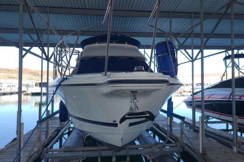 Slide: The Image of 2007 Bayliner Discovery 288 boat docked in a marina under a metal roof. - 8