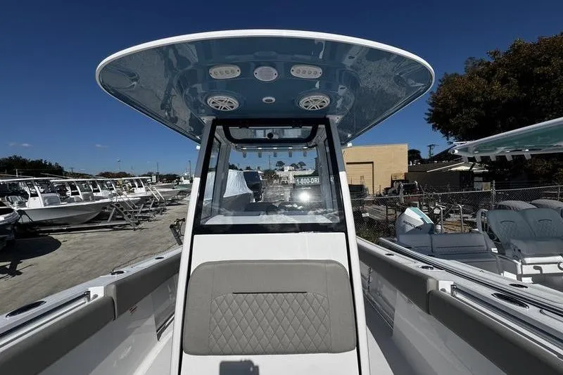 Slide: The Image of 2026 Sportsman Open 252 Center Console boat at a marina under clear blue sky. - 13