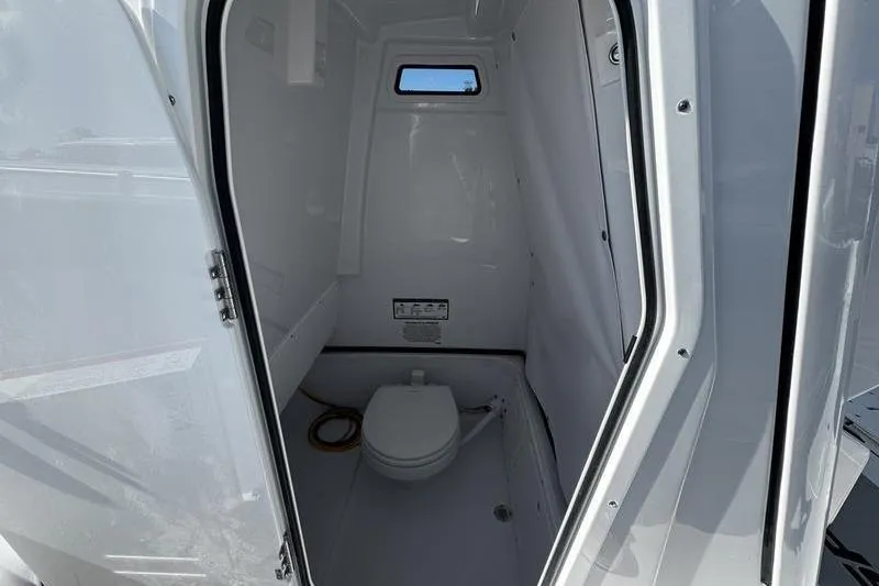 Slide: The Image of Interior of 2026 Sportsman Open 252 Center Console boat's compact bathroom. - 14