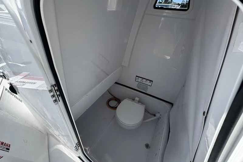 Slide: The Image of Interior of 2026 Sportsman Open 252 Center Console boat with compact marine toilet. - 15