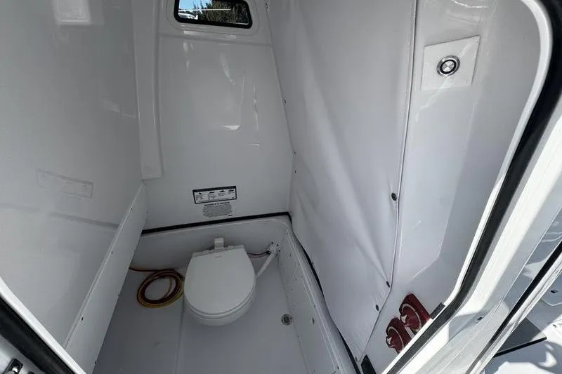 Slide: The Image of Interior of 2026 Sportsman Open 252 Center Console boat with compact marine toilet. - 16