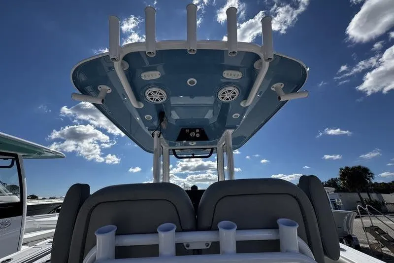 Slide: The Image of 2026 Sportsman Open 252 Center Console boat, viewed from below, showcasing rod holders and speakers. - 31