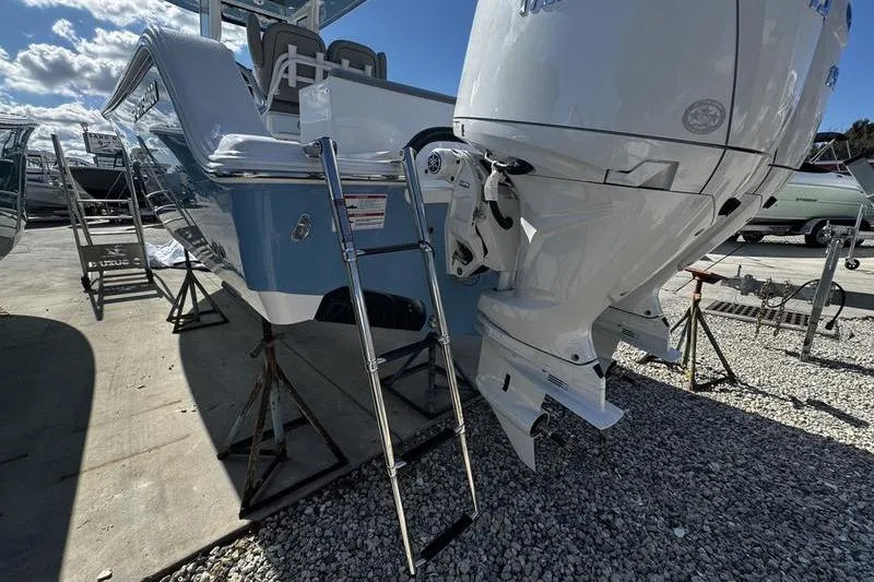 Slide: The Image of 2026 Sportsman Open 252 Center Console boat with outboard motor and ladder. - 34