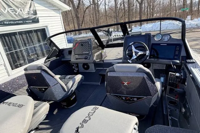 Slide: The Image of 2026 Vexus DVX22 boat interior with modern dashboard and seating, parked outdoors. - 6