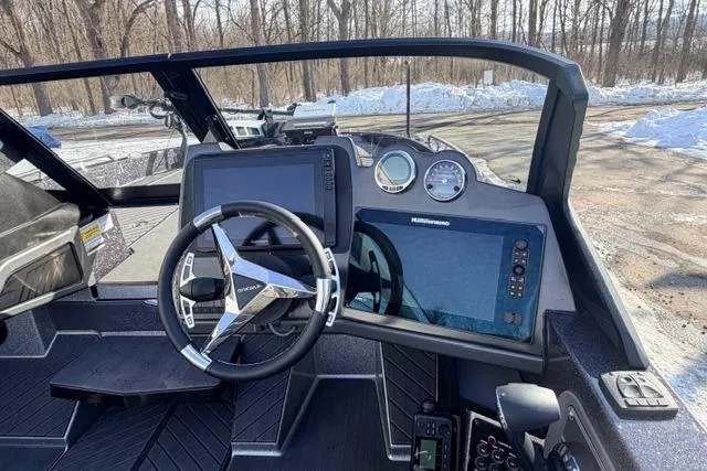 Slide: The Image of 2026 Vexus DVX22 boat dashboard with steering wheel and digital displays in snowy setting. - 7