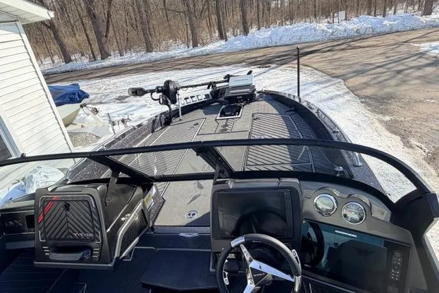 Slide: The Image of 2026 Vexus DVX22 boat interior with advanced dashboard and steering, parked in snowy setting. - 8