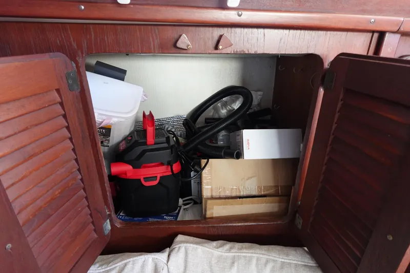 Slide: The Image of Storage compartment in a 1978 Morgan 382 sailboat with various equipment and supplies. - 33