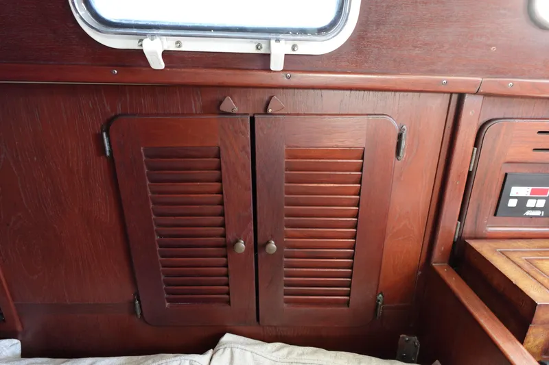 Slide: The Image of 1978 Morgan 382 sailboat interior with wooden cabinets and porthole. - 34