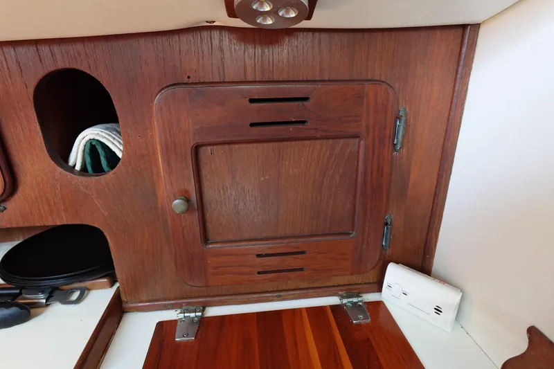 Slide: The Image of Wooden interior of a 1978 Morgan 382 sailboat, featuring a cabinet and storage area. - 60
