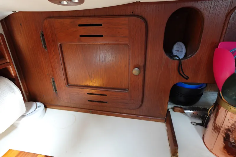 Slide: The Image of 1978 Morgan 382 yacht interior with wooden cabinetry and kitchen utensils. - 64