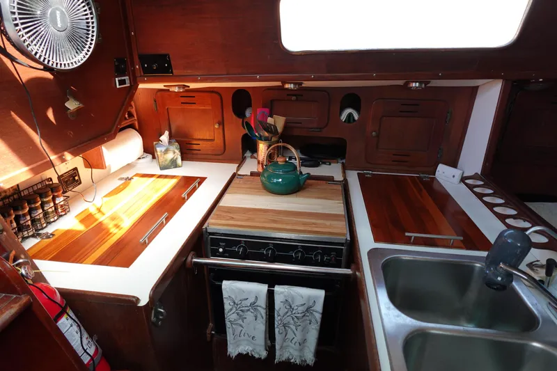 Slide: The Image of 1978 Morgan 382 yacht kitchen with wooden cabinetry, stove, sink, and teal kettle. - 68