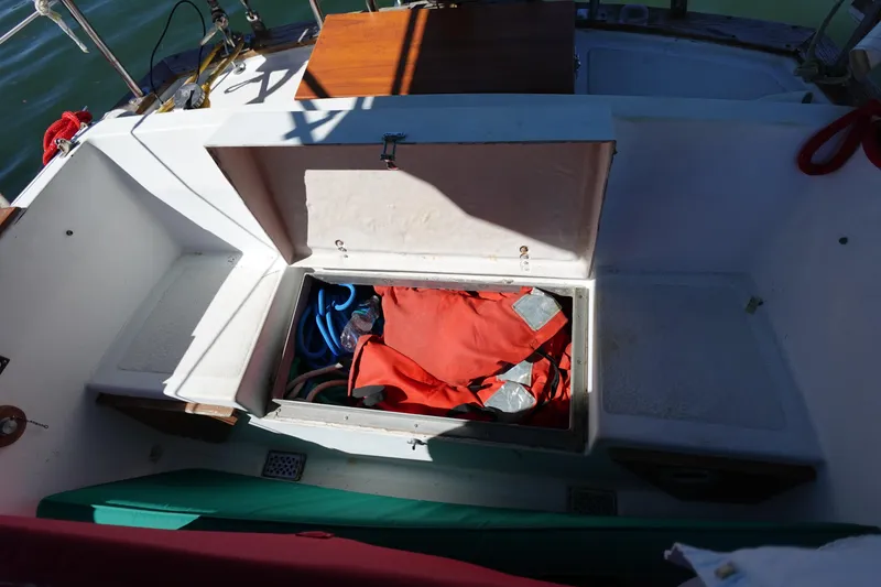 Slide: The Image of 1978 Morgan 382 sailboat cockpit storage with red life jacket and blue rope. - 79