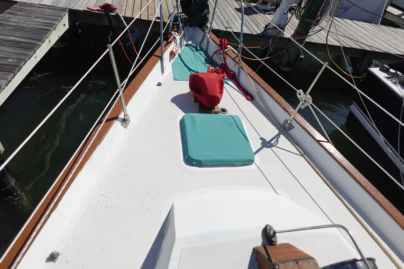 Slide: The Image of 1978 Morgan 382 sailboat deck with teal hatches and red ropes at dock. - 10