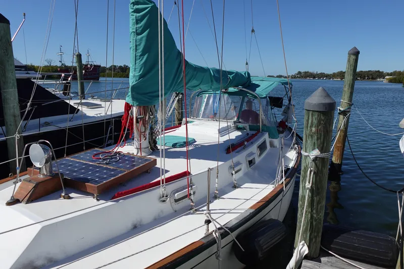 Slide: The Image of 1978 Morgan 382 sailboat docked, featuring solar panel and green sail cover. - 3
