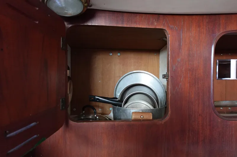 Slide: The Image of Wooden cabinet with cookware inside a 1978 Morgan 382 sailboat. - 39