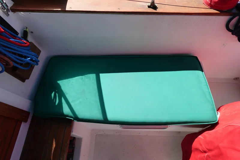 Slide: The Image of Green cushioned seat on 1978 Morgan 382 sailboat with colorful ropes nearby. - 73