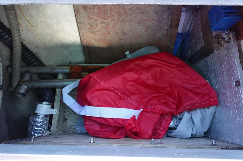 Slide: The Image of Storage compartment in a 1978 Morgan 382 sailboat with red and gray gear. - 74
