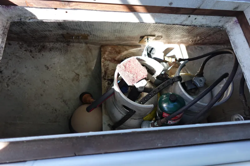 Slide: The Image of Storage compartment of a 1978 Morgan 382 sailboat with propane tanks and equipment. - 81