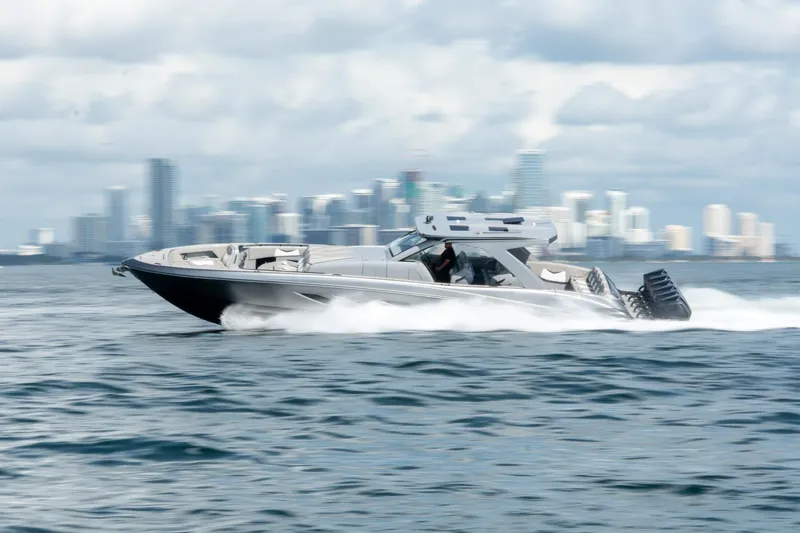 Slide: The Image of 2026 Deep Impact 499 Sport boat speeding on water with city skyline in background. - 15