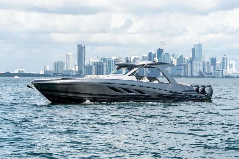Slide: The Image of Luxury Deep Impact 499 Sport boat cruising near city skyline, 2026 model. - 22