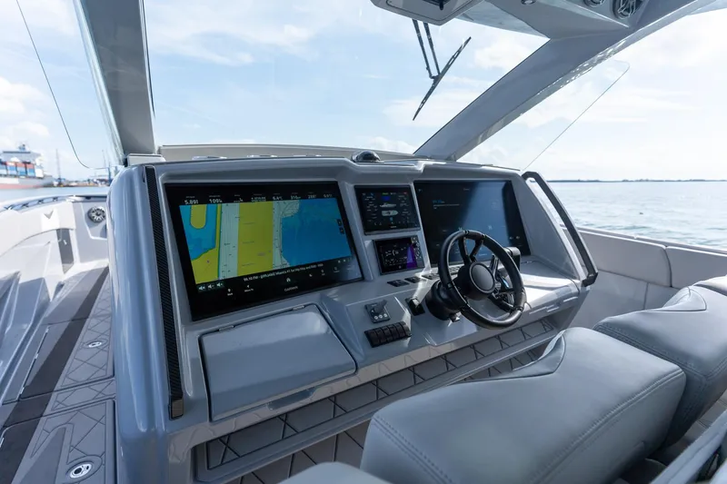 Slide: The Image of 2026 Deep Impact 499 Sport boat cockpit with advanced navigation screens and steering wheel. - 27