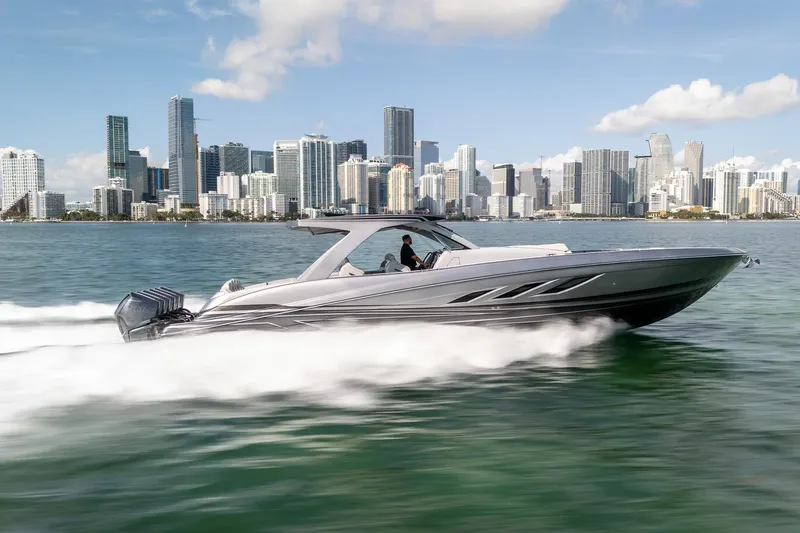Slide: The Image of 2026 Deep Impact 499 Sport boat speeding on water with city skyline backdrop. - 6