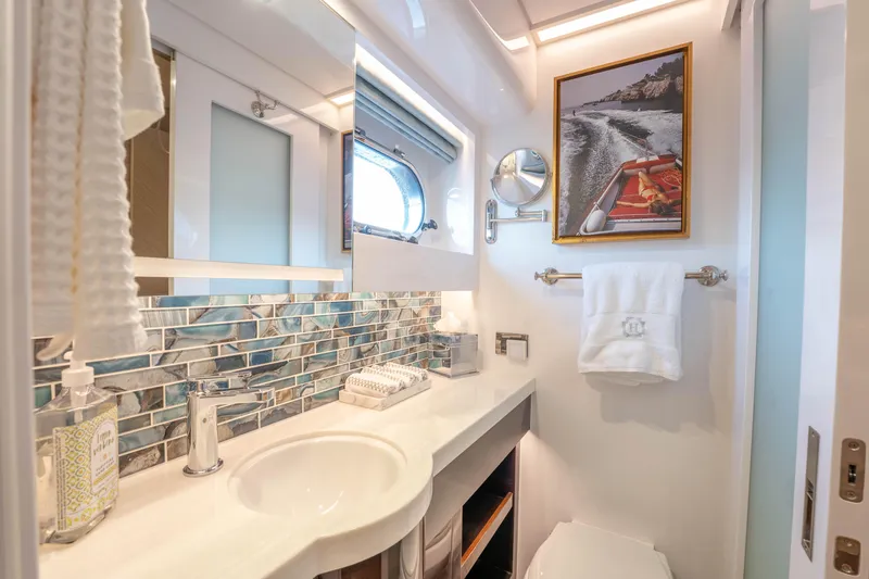 Slide: The Image of Luxurious yacht bathroom with modern fixtures, ocean-themed decor, and framed boat photo. - 29