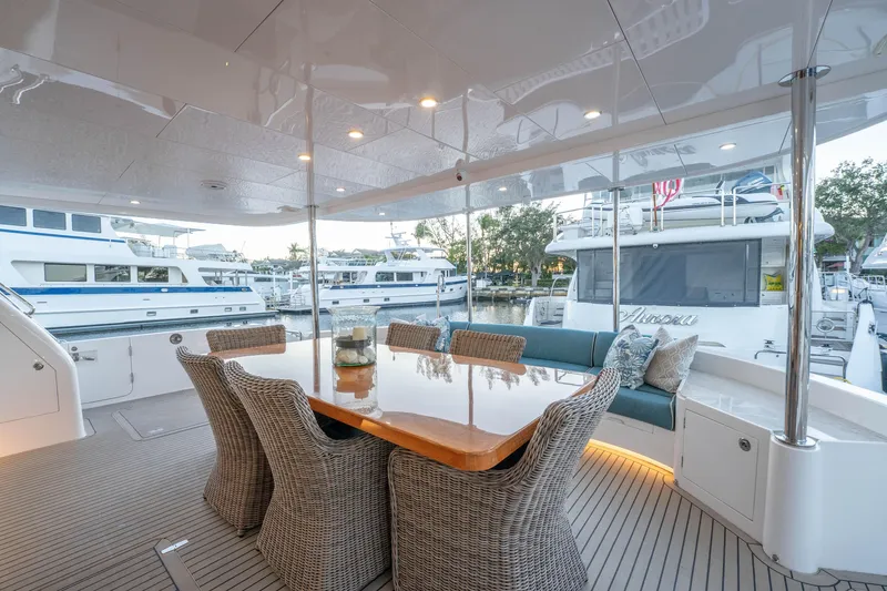 Slide: The Image of Luxurious Horizon yacht deck with dining area, wicker chairs, and marina view, 2021 model. - 44