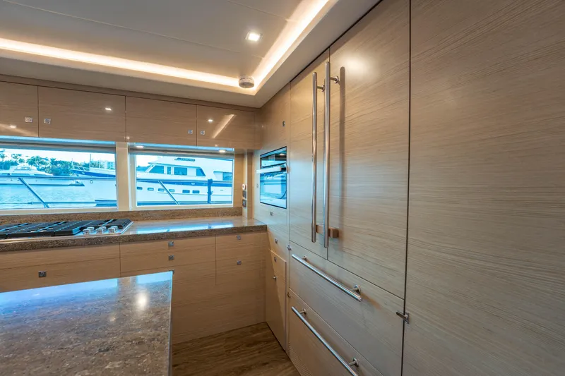 Slide: The Image of Luxurious 2021 Horizon yacht kitchen with modern wood cabinetry and ocean view. - 5