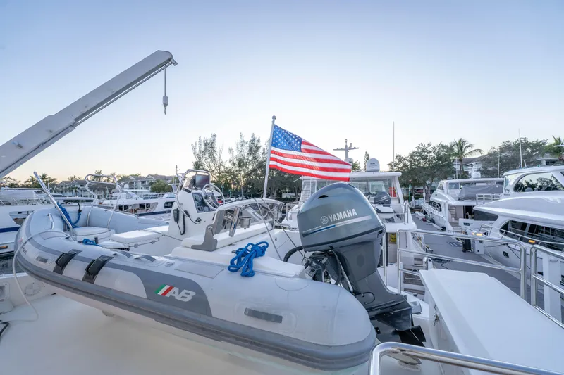 Slide: The Image of Inflatable boat with Yamaha motor and American flag, docked at marina, Horizon 2021. - 60