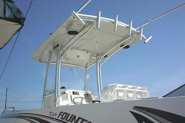 Slide: The Image of 1996 Fountain 31 Center Console boat with T-top and rod holders against blue sky. - 18