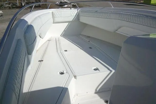 Slide: The Image of 1996 Fountain 31 Center Console boat interior with white seating and storage compartments. - 20