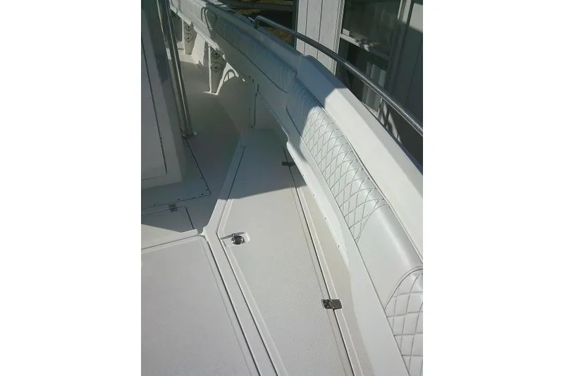 Slide: The Image of 1996 Fountain 31 Center Console boat interior with white cushioned seating and storage compartments. - 27