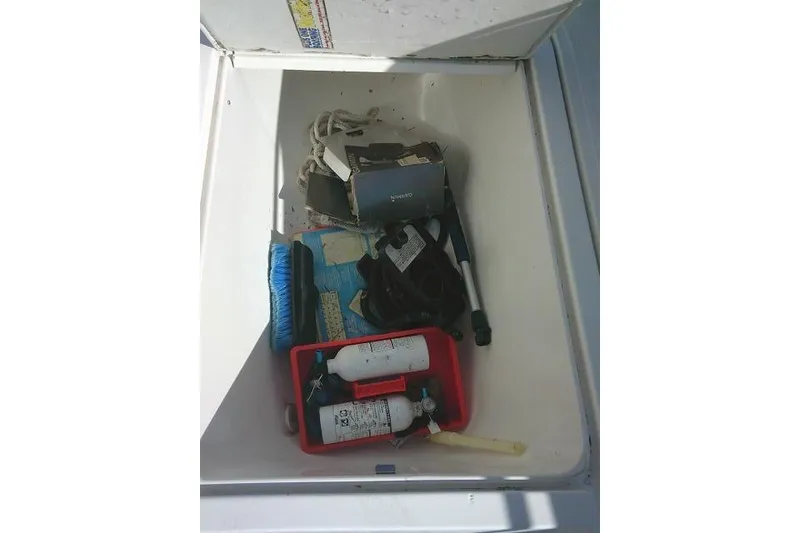 Slide: The Image of Storage compartment of 1996 Fountain 31 Center Console boat with various equipment. - 31