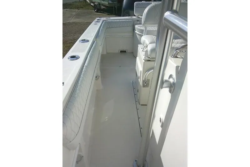 Slide: The Image of 1996 Fountain 31 Center Console boat interior with cushioned seating and rod holders. - 32