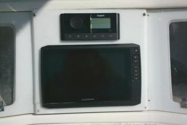 Slide: The Image of Control panel of a 1996 Fountain 31 Center Console boat with Garmin and Fusion devices. - 47