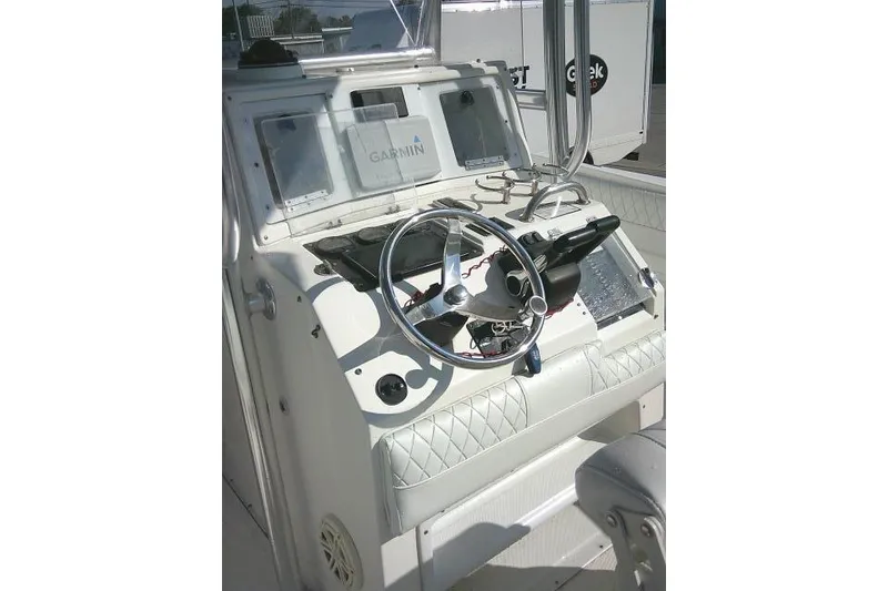 Slide: The Image of 1996 Fountain 31 Center Console boat dashboard with steering wheel and Garmin navigation system. - 49