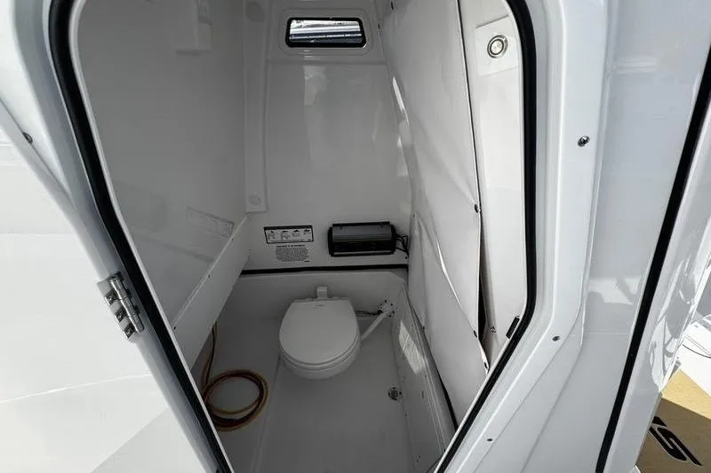 Slide: The Image of 2026 Sportsman Open 252 Center Console boat interior with compact marine toilet. - 14
