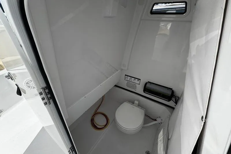 Slide: The Image of 2026 Sportsman Open 252 Center Console boat interior with compact marine toilet. - 15