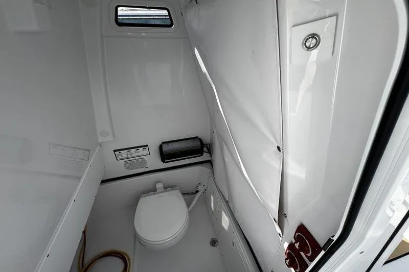 Slide: The Image of 2026 Sportsman Open 252 Center Console boat interior with compact marine toilet. - 16