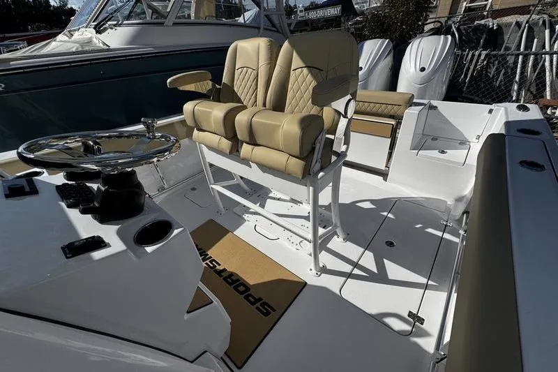 Slide: The Image of 2026 Sportsman Open 252 Center Console boat interior with dual beige seats and steering wheel. - 17