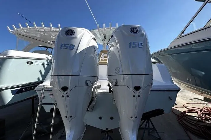 Slide: The Image of 2026 Sportsman Open 252 Center Console with dual 150 horsepower engines, docked under clear skies. - 3