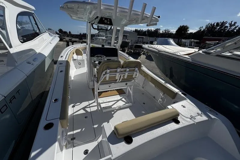 Slide: The Image of 2026 Sportsman Open 252 Center Console boat with seating and console, docked under clear sky. - 4