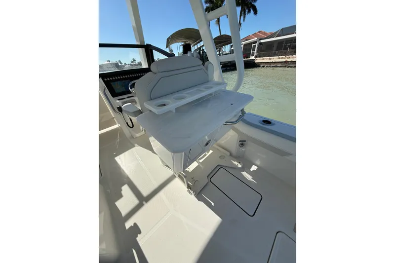 Slide: The Image of 2025 World Cat 260 DC-X boat interior with seating and cup holders, dockside view. - 10