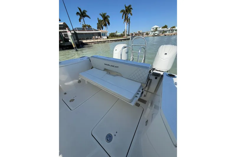 Slide: The Image of 2025 World Cat 260 DC-X boat with seating, docked near palm trees. - 11